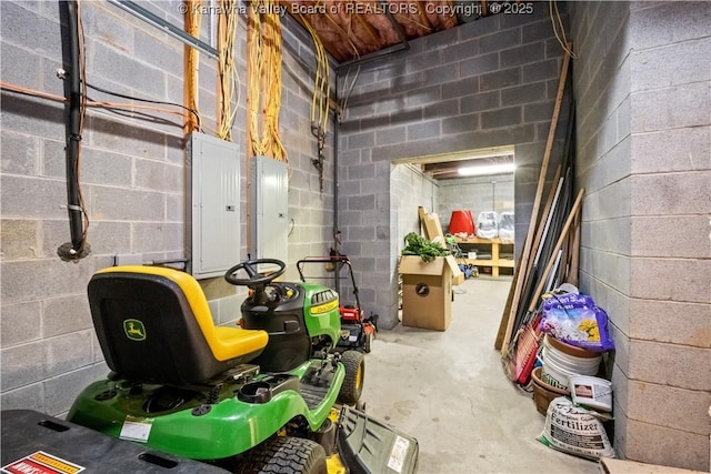 basement featuring concrete block wall and electric panel