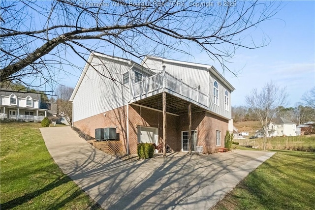 rear view of house featuring a yard, brick siding, and cooling unit