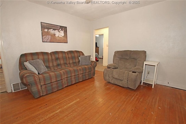 living room featuring visible vents and hardwood / wood-style floors