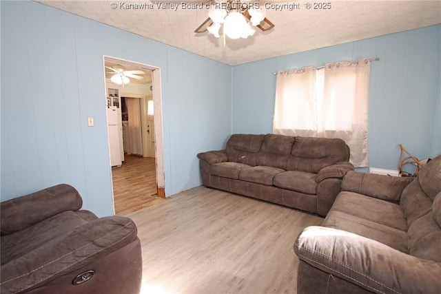 living room with light wood-style floors and a ceiling fan