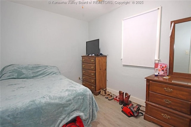 bedroom featuring wood finished floors and baseboards