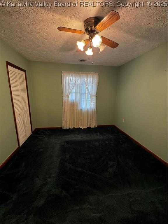 spare room featuring a ceiling fan, carpet, a textured ceiling, and baseboards