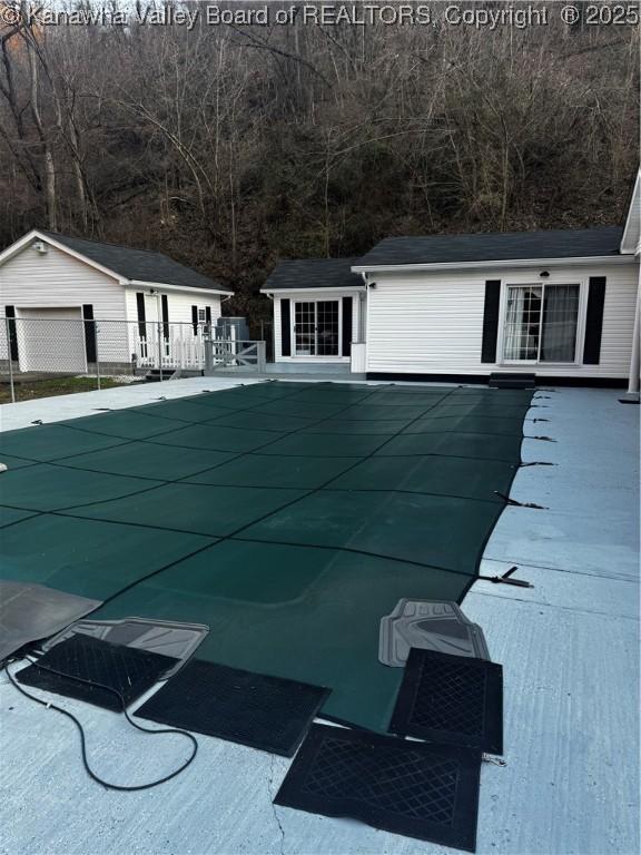 view of pool featuring a patio area, fence, a fenced in pool, and an outbuilding