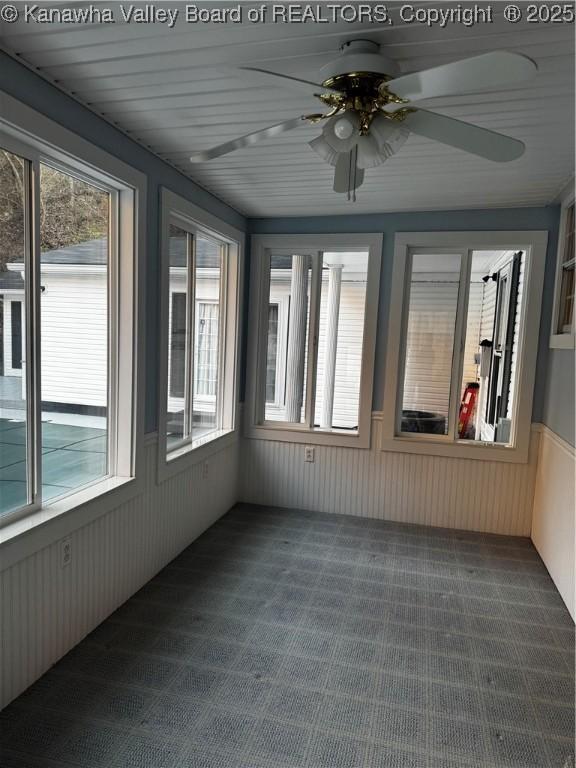 unfurnished sunroom with ceiling fan