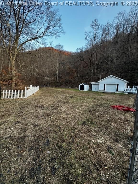 view of yard featuring fence and an outbuilding