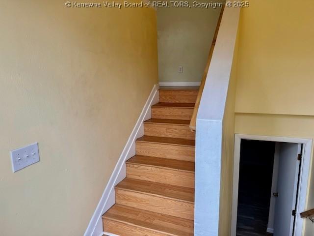 stairs with wood finished floors and baseboards