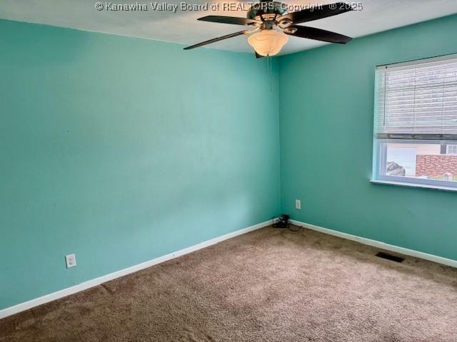 unfurnished room featuring a ceiling fan, carpet, visible vents, and baseboards