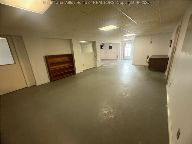 basement featuring a drop ceiling and baseboards