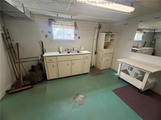 bathroom with a paneled ceiling, concrete floors, and a sink