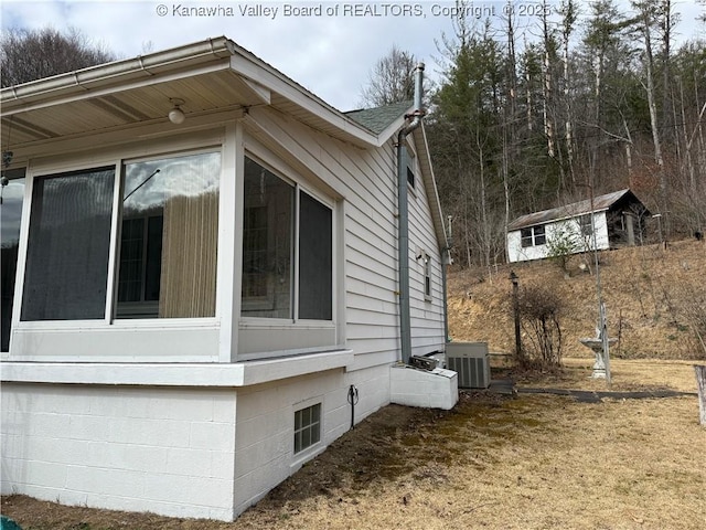 view of side of home featuring central AC and a sunroom