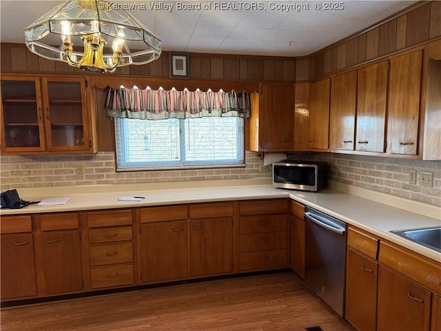 kitchen with light countertops, appliances with stainless steel finishes, brown cabinetry, and light wood-style floors