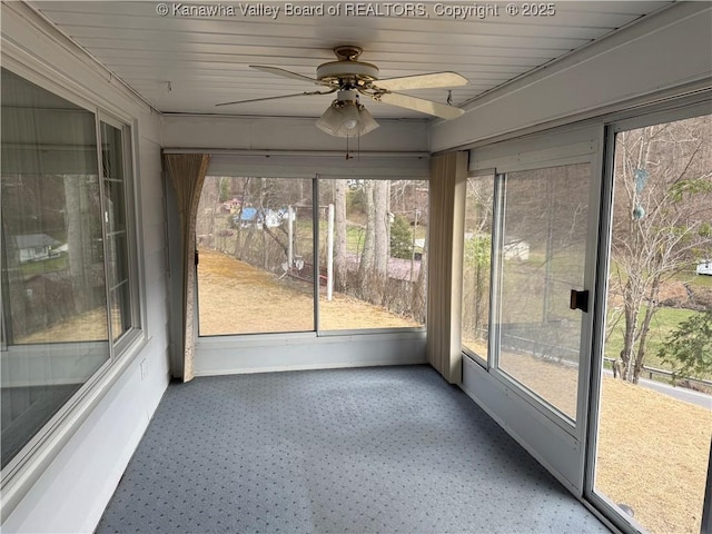 unfurnished sunroom featuring ceiling fan