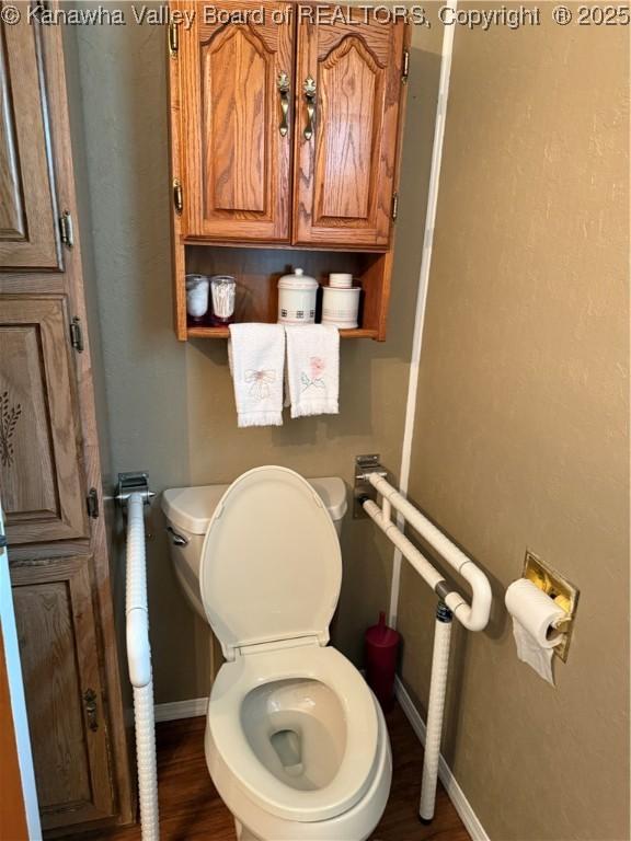 bathroom featuring toilet, baseboards, and wood finished floors