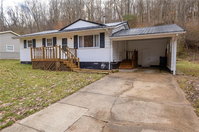 view of front facade featuring crawl space, metal roof, a carport, driveway, and a front lawn