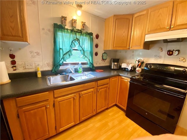 kitchen with under cabinet range hood, dark countertops, a sink, and black electric range oven