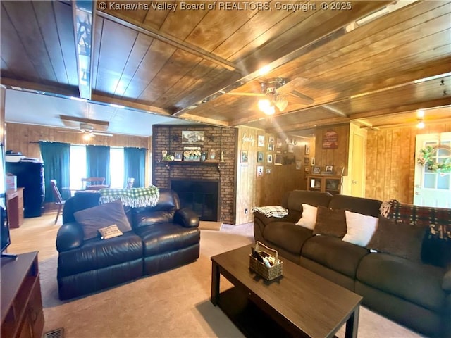 carpeted living area with wood ceiling, wood walls, beam ceiling, and ceiling fan