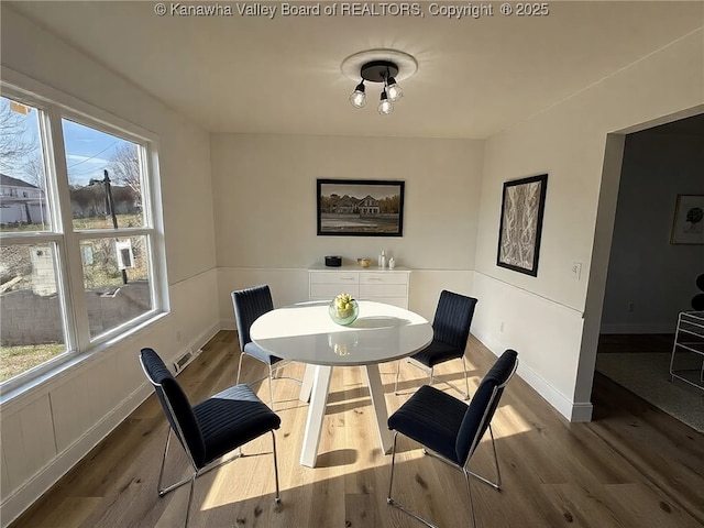 dining space featuring wood finished floors and baseboards