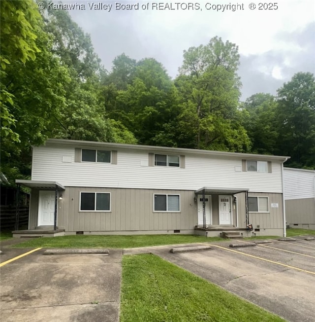 view of property with uncovered parking, a front yard, and crawl space