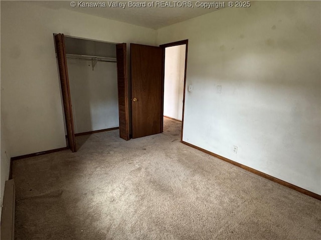 unfurnished bedroom featuring carpet floors, baseboards, and a closet