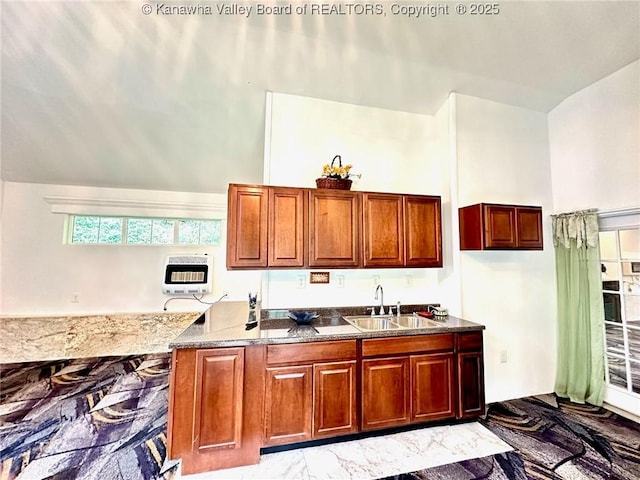 kitchen with dark stone counters, a towering ceiling, heating unit, marble finish floor, and a sink