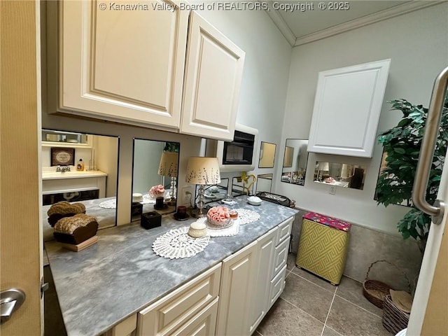 kitchen with ornamental molding, white cabinetry, and light tile patterned floors