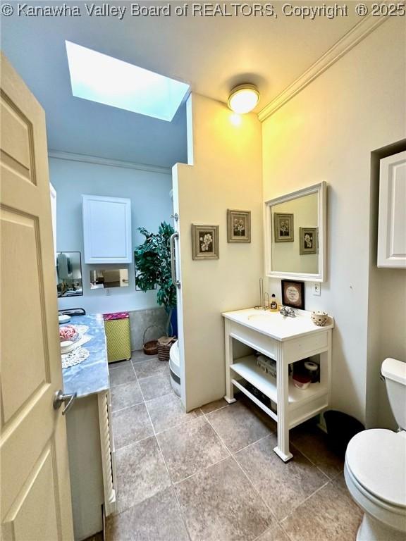 bathroom featuring ornamental molding, vanity, and toilet