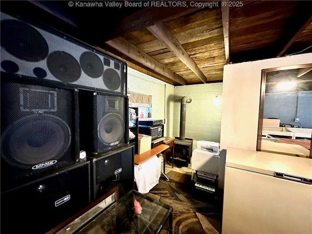 office space with a wood stove, wooden ceiling, and concrete block wall