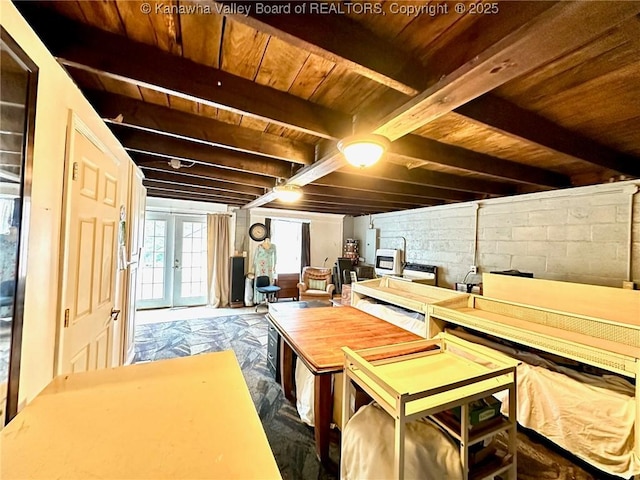 interior space with concrete block wall, wood ceiling, beamed ceiling, and french doors