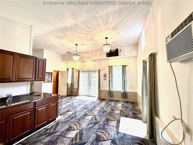 kitchen featuring french doors, a wall mounted air conditioner, and decorative light fixtures