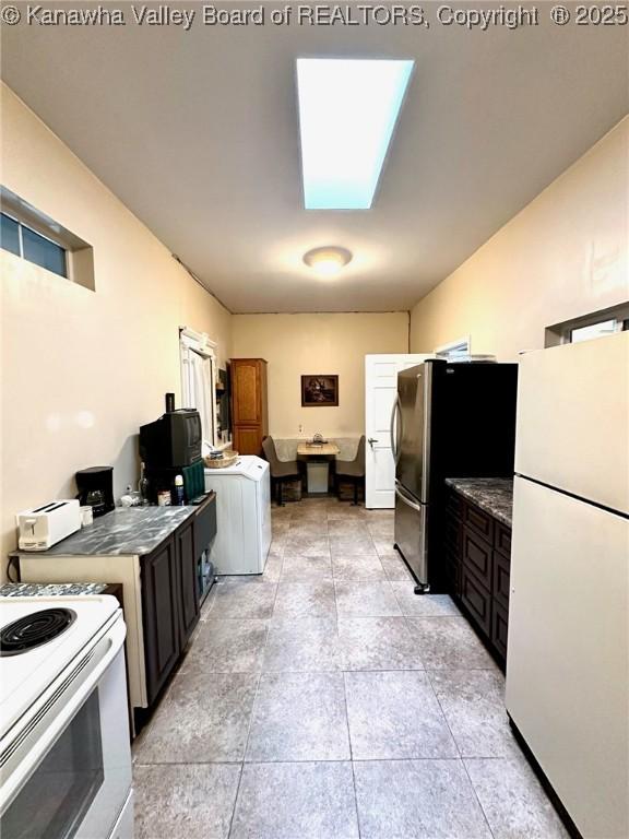 kitchen featuring white appliances, a skylight, and washer / dryer