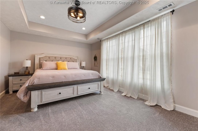 bedroom with a tray ceiling, carpet, recessed lighting, visible vents, and baseboards