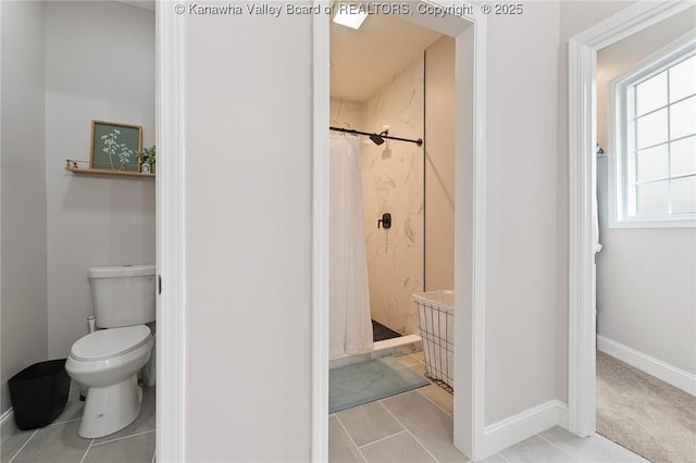 full bathroom with a stall shower, baseboards, toilet, and tile patterned floors