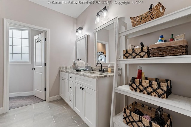 bathroom featuring vanity, baseboards, and tile patterned floors