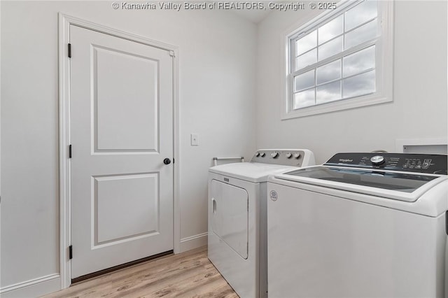 washroom with laundry area, light wood finished floors, washing machine and dryer, and baseboards