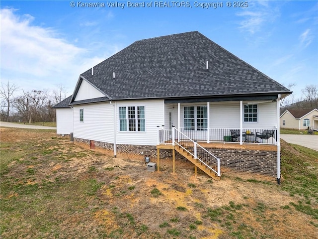 rear view of house with a porch and roof with shingles