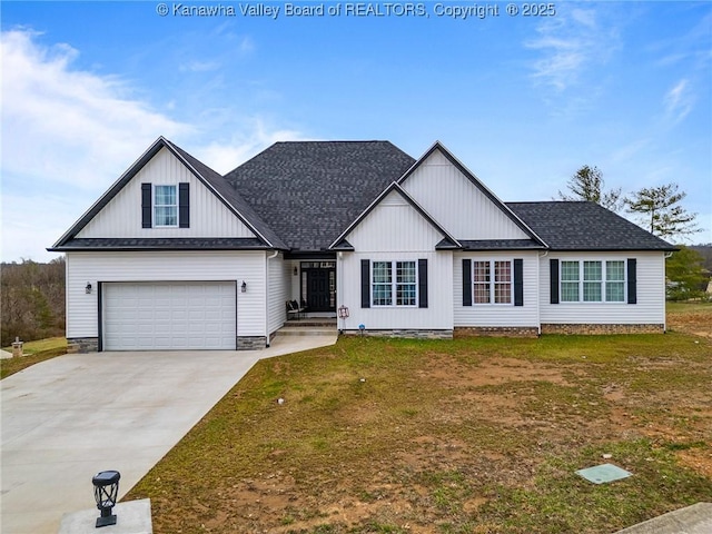 view of front facade with concrete driveway, roof with shingles, and a front yard