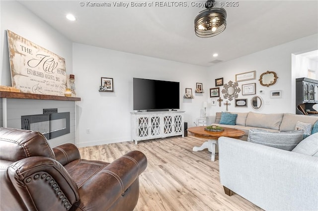 living area with baseboards, a fireplace, wood finished floors, and recessed lighting