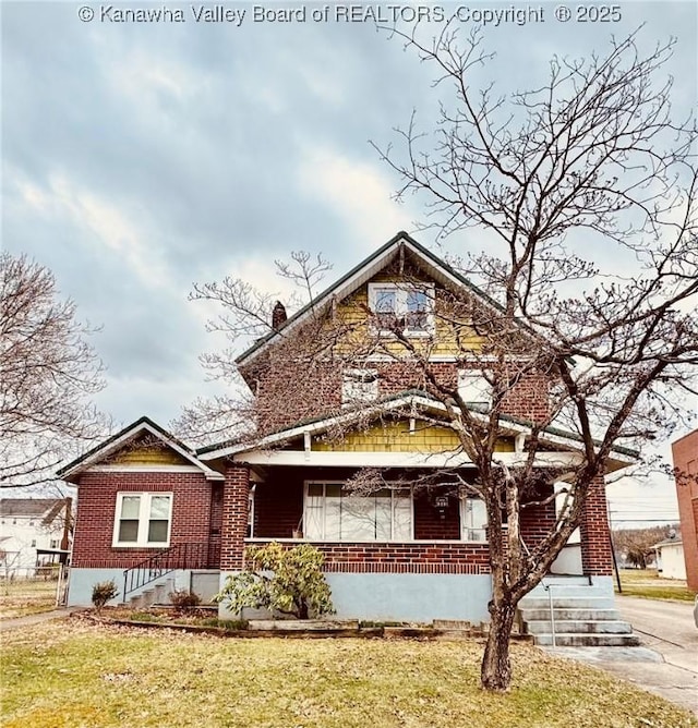 view of front facade featuring a porch, brick siding, and a front lawn