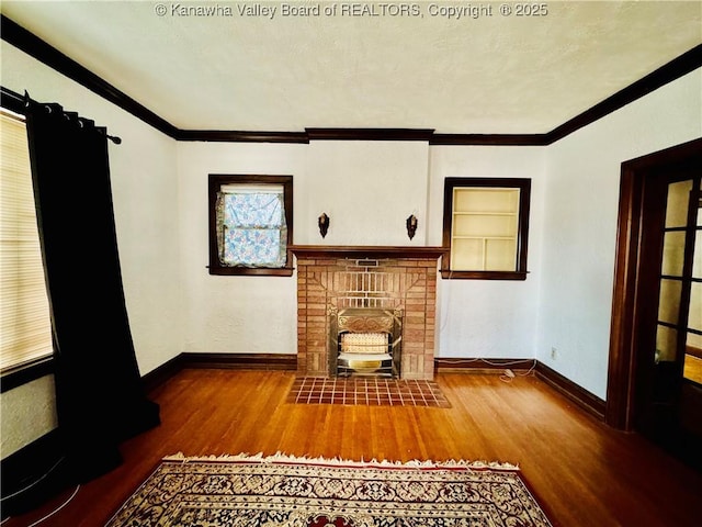 unfurnished living room featuring a brick fireplace, wood finished floors, and crown molding