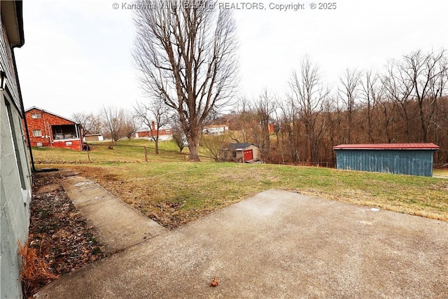 view of yard with an outbuilding, a patio area, and fence