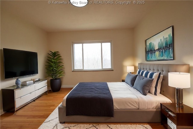 bedroom with baseboards and wood finished floors