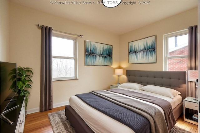 bedroom with light wood-type flooring and baseboards