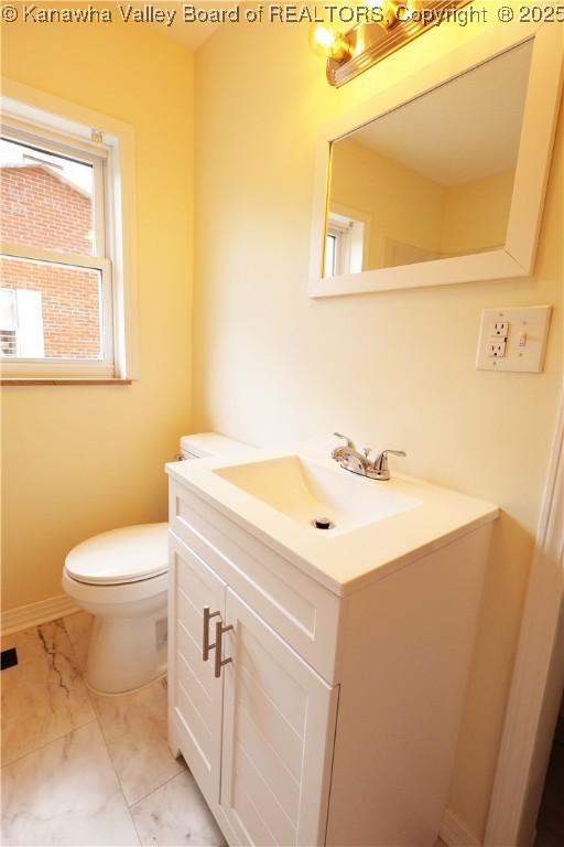 bathroom featuring marble finish floor, vanity, toilet, and baseboards