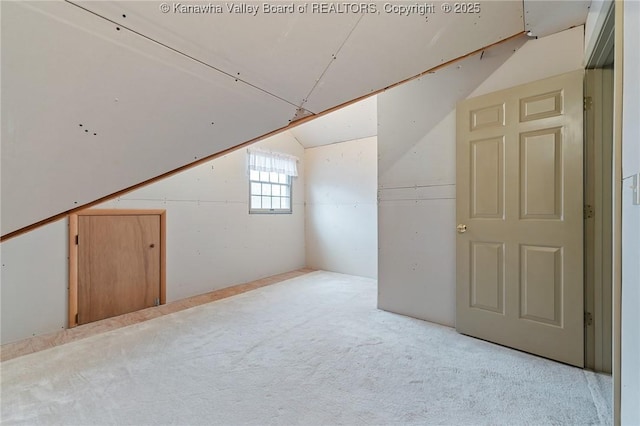 additional living space featuring carpet floors and vaulted ceiling