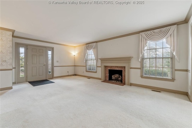 unfurnished living room featuring ornamental molding, a wealth of natural light, carpet flooring, and baseboards