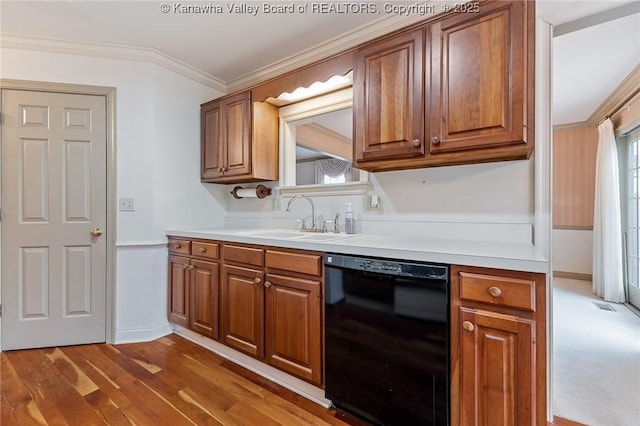 kitchen with black dishwasher, brown cabinets, light countertops, crown molding, and a sink