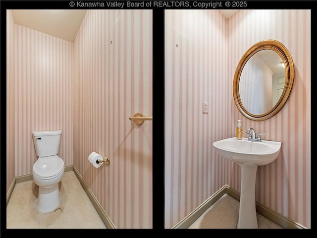 half bathroom featuring baseboards, toilet, and wallpapered walls