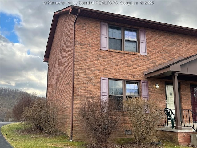 view of property exterior featuring brick siding and crawl space