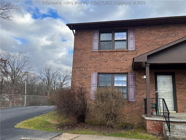 view of front of property featuring driveway and brick siding