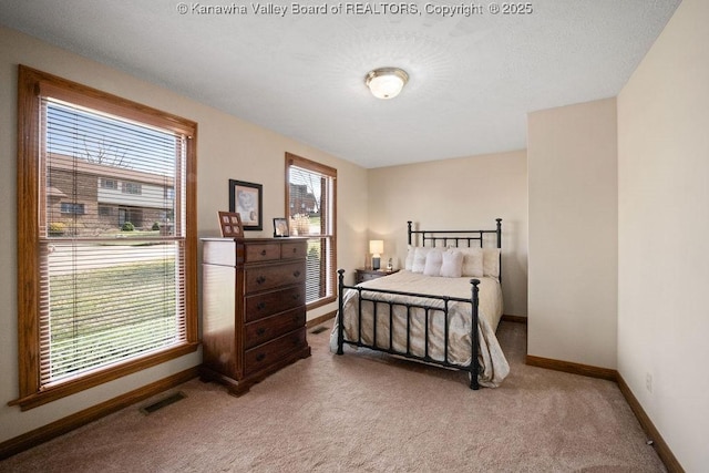 bedroom featuring light carpet, visible vents, and baseboards